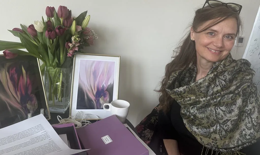 Žena u stolu s květinami a obrazy při setkání Aktivace kódů duše